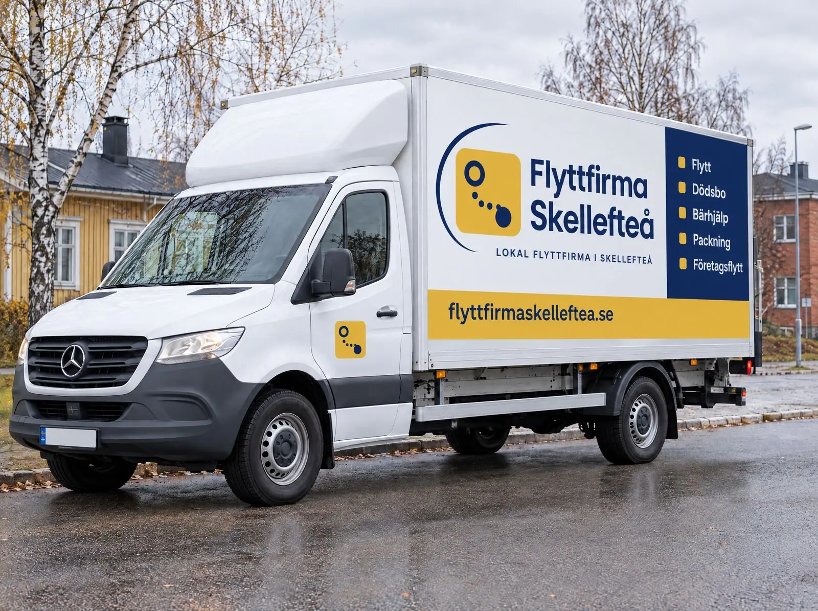 White removal van with the yellow and blue Flyttfirma Skellefteå livery parked on a street in Skellefteå on an autumn day.