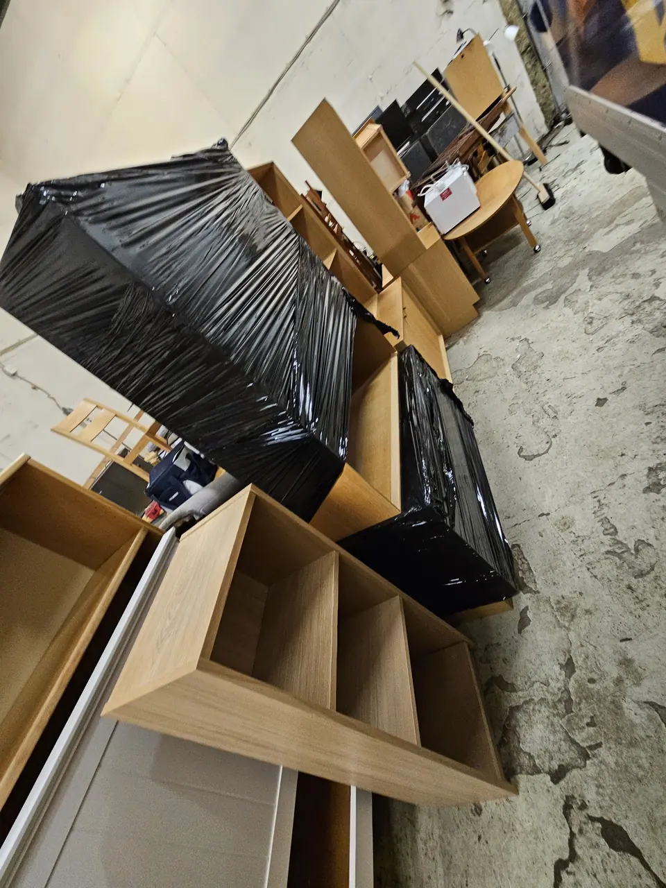 Bookcases and furniture wrapped in plastic and stacked before loading.