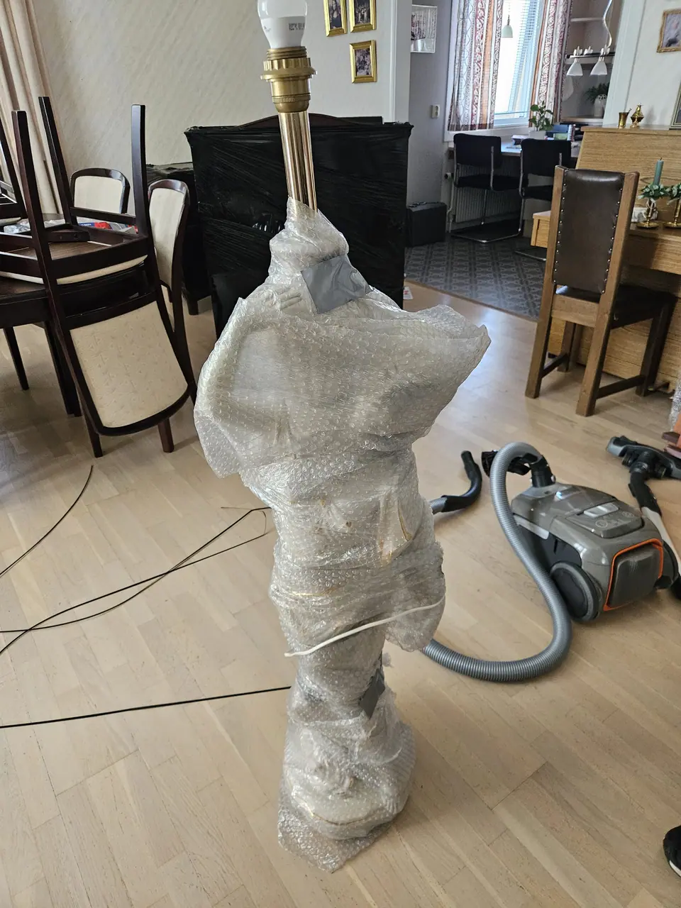 A floor lamp wrapped in bubble wrap.
